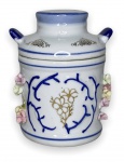 CHINA - Gracioso potiche em porcelana branca esmaltada adornada com motivo floral em vibrante ouro e apliques em biscuit em policromia. Acompanha sua respectiva tampa com pega. Possui registro da manufatura na base. Apresenta sinais de restauro. Mede 13cm.