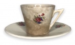 PORTUGAL - Elegante xícara para café em porcelana branca esmaltada, ricamente adornada com motivo floral em policromia e resquícios de contorno em vibrante ouro. Acompanha seu respectivo pires. Possui registro da manufatura na base. Marcas do tempo.