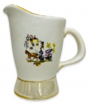 EUROPA - Elegante leiteira em porcelana branca esmaltada ricamente adornada com cena urbana com charrete em policromia e contorno em vibrante ouro. Mede 11cm de altura x 12cm de cumprimento.