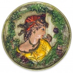 Antigo medalhao para parede em estuque, adornado com figura feminina em relevo em policromia. Possui orificio para pendurar. Mede 18cm diametro.
