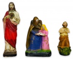 Trio de antigas imagens sacras sendo Sant'Anna, Sagrado Coração de Jesus e outra não decifrada, santo de joelhos, assinada e datada na base, em estuque policromado. Medida da maior 16cm.