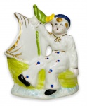 EUROPA 1900 - Graciosa escultura em porcelana européia esmaltada, adornada com detalhes em vibrante ouro e policromia, representando figura de marinheiro. Mede 10 x 8cm.