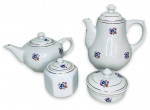 ANOS 60 - Elegante serviço para chá e café em porcelana branca esmaltada, composto de bule para chá, bule para café, açucareiro e mantegueira, ricamente adornados com motivo floral em policromia e contorno em vibrante ouro. Discreto fio de cabelo em um dos bules. Acompanham suas respectivas tampas. Medida do maior 22 x 21cm.