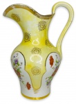 ANOS 50 - Elegante jarro com alça em porcelana Pedreira esmaltada em amarelo, ricamente adornada com ramalhete de flores em policromia e contorno em vibrante ouro. Fio de cabelo na alça. Possui registro da manufatura na base. Mede 28cm altura x 20cm largura.