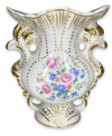 RAMI - Elegante floreira com alças em porcelana branca esmaltada ricamente adornada com motivo floral em policromia e contorno em vibrante ouro, borda em movimento. Apresenta registro da manufatura na base. Mede 15cm de comprimento x 17cm de altura.