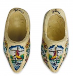 HOLLAND - Par de antigas e graciosas esculturas em madeira patinada representando sapatos holandeses ricamente adornadas com motivo floral e paisagem com moinhos em policromia. Desgaste do tempo. Mede 11cm cada.