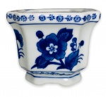 BOMBAY CHINA  SÉC XIX - Elegante e rara floreira em porcelana chinesa branca esmaltada, ricamente adornada com motivo floral na cor azul royal, apoiada sobre base em movimento. Possui registro da manufatura na base. Mede 8cm x 10cm.