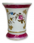 EUROPA - Elegante floreira em porcelana branca esmaltada ricamente adornada com motivo floral em policromia e contorno em vibrante ouro. Marcas do tempo. Mede 9cm de altura.