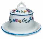 PORCELANA PEDRO II - Gracioso açucareiro em porcelana branca esmaltada ricamente adornado com motivo floral em policromia pintada a mão. Acompanha sua respectiva tampa com pega e orifício para colher. Possui registro da manufatura na base. Mede 9cm de altura x 13cm de comprimento.