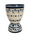 Graciosa taça no formato de cálice, em porcelana esmaltada adornada com motivo floral na cor azul. Apresenta assinatura na base. Mede 10cm altura.