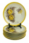 Jogo de 8 elegantes pratos rasos em porcelana esmaltada ricamente adornados à mão com motivo floral em policromia. Apresenta assinatura. Mede 26cm diametro.