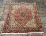 Elegante tapete persa adornado com motivo floral. Usado.Necessita limpeza.  Mede 2,50 x2,10m.
