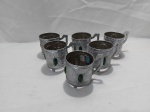 Jogo de 6 suportes de xícaras de café  em metal prateado. Medindo 6,5cm de diâmetro x 6,5cm de altura.
