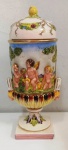 Belíssimo e antigo  pote de mesa em porcelana italiana em alto relevo ricamente policromado representando cenas com querubins no campo . Mínimos bicados Mede: 27 cm