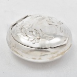 Caixa em prata ricamente cinzelada com flores, altura 3 cm e diâmetro 7,5 cm, com 42 grs.