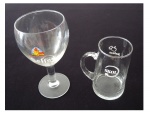Uma taça para vinho tinto em cristal com medalhão e grafada Seffe, e uma caneca para cerveja Skol em vidro com estalado na alça, Alt. 20 e 14 cm.
