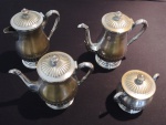 Baixela com 4 peças espessuradas à prata com tampa e bojo canelados, asas recurvas e bico de pato, composta de: 2 bules, 1 leiteira e um açucareiro, com marcas do tempo, Alt. 22 a 14 cm.