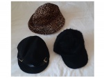Um chapéu de oncinha e dois bonés pretos um deles em pelo sintético.