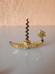 Antigo abridor para vinhos (saca rolhas) em formato de um navio viking em estanho banhado a ouro. A peça  se encontra com desgastes no banho  e um pequeno desgaste na polpa do navio. Estando em condições  de uso. Década de 40.Medidas: Comprimento:9cm  Altura:7cm
