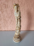 Antiga estátua de gueixa japonesa segurando instrumento de corda. Feita em gesso patinado, a peça é datada de 1975 e está em perfeito estado de conservação. Altura: 36cm; Diâmetro da base: 9cm.