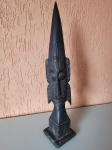 Antiga carranca africana esculpida em madeira, pintada com tinta de cor preta. A peça tem algumas marcas do tempo, mas está em bom estado de conservação. Altura: 50cm; Medidas da base: 10cmX10cm.