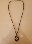 Antigo cordão  com medalha do Sagrado Coração de Jesus. Trabalhada em metal amarelo com pedras, faltando algumas. Década de 90. A peça se encontra em bom estado de conservação. Medidas: medalha:3x4cm    corrente:33cm