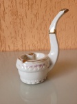 Cinzeiro de porcelana em formato de cachimbo, com detalhes dourado e alto relevo na lateral. A peça é da década de 50 e está em bom estado de conservação, somente com alguns desgastes na pintura realizada no alto relevo. Madidas: Diâmetro da boca:6cm   Diâmetro  do fundo:5cm    Altura do Cinzeiro:5cm    Altura do braço do cachimbo:10cm