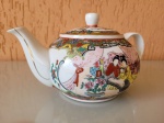 Antigo bule chinês de porcelana, com detalhes em folha de ouro e pintado à mão. Feito pela "Lotus Blooms Brand", da china. Altura: 12cm; Comprimento (da asa ao bico): 21,5cm; Largura: 14cm.