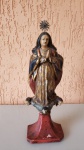 Antiga imagem sacra de Nossa Senhora da Conceição do século XVIII (arte barroca mineira), esculpida em cedro, detalhada em folha de ouro, policromia e olhos de vidro, a peça contém um resplendor de prata com uma pedra de rubi no centro, que é removível. Tendo de altura: 27cm, largura: 10 cm , pesa aproximadamente 150g.
