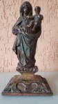 Rara imagem sacra, feita de terracota no século XVII. O item possui base ricamente entalhada em madeira de lei, sua pintura é composta por policromia e folha de ouro. Tendo de altura: 24cm, largura: 10cm e pesa aproximadamente 750 g.  Base: 12x10