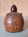 Antiga perfumeira feita em um casulo de castanha do Pará, com tampa de madeira. Feita nos anos 50, a peça está em excelente estado de conservação. Altura: 11,5cm; Diâmetro: 8,5cm.
