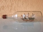 Antigo navio feito dentro de uma garrafa. A ponta do navio está desencaixada e deve ser reparada, como se vê nas fotos. Altura: 9cm; Comprimento: 30cm; Largura: 8cm.