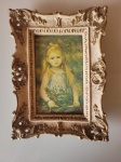 Antiga gravura, réplica da obra "Menina com as espigas", do artista francês Pierre-Auguste Renoir. A peça possui uma imponente moldura, feita em madeira e é provavelmente dos anos 40. Altura: 20,5cm; Comprimento: 14cm; Largura: 2cm.