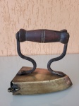 Antigo ferro de cunha para passar roupa. A peça falta a trava e a cunha. Está em bom estado de conservação, mas tem uma rachadura no cabo de madeira e está um pouco bambo. O item é feito em bronze. Altura: 12cm; Comprimento: 11cm; Largura: 6cm.