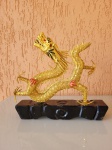 Porta-incenso em forma de dragão chinês. A peça é feita em metal dourado, tem detalhes em vermelho e preto e tem base preta de madeira. Está em excelente estado. Altura total: 22cm; Comprimento da base: 23cm; Largura da base: 4,5cm.