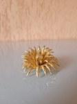 Antigo broche de flor dourado com pérola sintética no meio de material não identificado.  A peça está em perfeito estado de conservação. Altura: 3cm   Diâmetro: 5cm