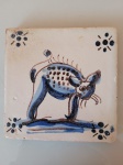Antigo azulejo estrelinha com desenho de gato com pintas. A peça vem de demolição de casarões do Rio de Janeiro e está em bom estado. Altura: 0,8cm; Dimensões: 13,5cmX13,5cm.
