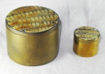 Duas caixas em metal dourado, provavelmente do Oriente Médio com interior em veludo e tampa encimada por lascas de concha maritima. Med.: 5x8cm e 3x4cm.