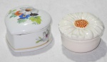 Duas caixas em porcelana, a saber: 1 no feitio de coração com pintura policromada (5x8cm) e 1 redonda no feitio de flor (4x7cm).