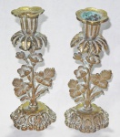 Par de castiçais em bronze com haste floral e base com concheados. (1 c/ a bobeche solta). Med.: 20cm.