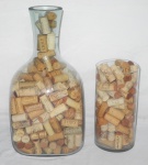 Dois potes em vidro recheados de rolha de bebidas.Med.Maior.40x19x19. Menor.24x12cm.
