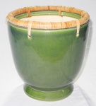 Cachepot em porcelana verde com borda guarnecida em fibra natural. Med.: 26x25cm.