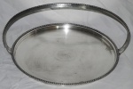 Grande bandeja redonda no feitio de cesta em metal espessurado a prata, com bordas e alças peroladas. (falhas na prateação). MARCA: MAGNA PRATA. Med.: 23x47x41cm.