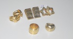 Três pares de brincos e dois anéis em metal dourado.