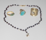Três anéis em metal dourado incrustadas com pedras ao centro, acompanha 1 colar com contas em pedras e cruz em metal dourado.