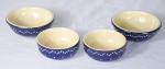 Quatro bowls em faiança alemã com pintura azul royal e pois brancos em relevo. Chancela do fabricante na base. Med.: 5x11cm e 5,5x13cm.