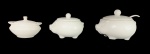 Três molheiras em porcelana branca, sendo duas no feitio de porcos, uma com concha. Med.: 9x13cm / 7,5x11cm / 11x15cm.