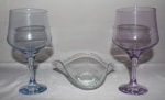 Duas taças em cristal, umas na roxa e outra na cor azul e uma petisqueira em cristal. Med.: Taças: Altura: 20,5; Diametro: 9cm. Petisqueira: 7,5x18cm.