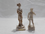 Lote de 2 enfeites na forma de esculturas em resina. Medindo 15,5cm de altura.