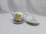 Jogo de xícara de chá com bule acoplado e manteigueira em porcelana. Medindo o conjunto 11cm de altura.